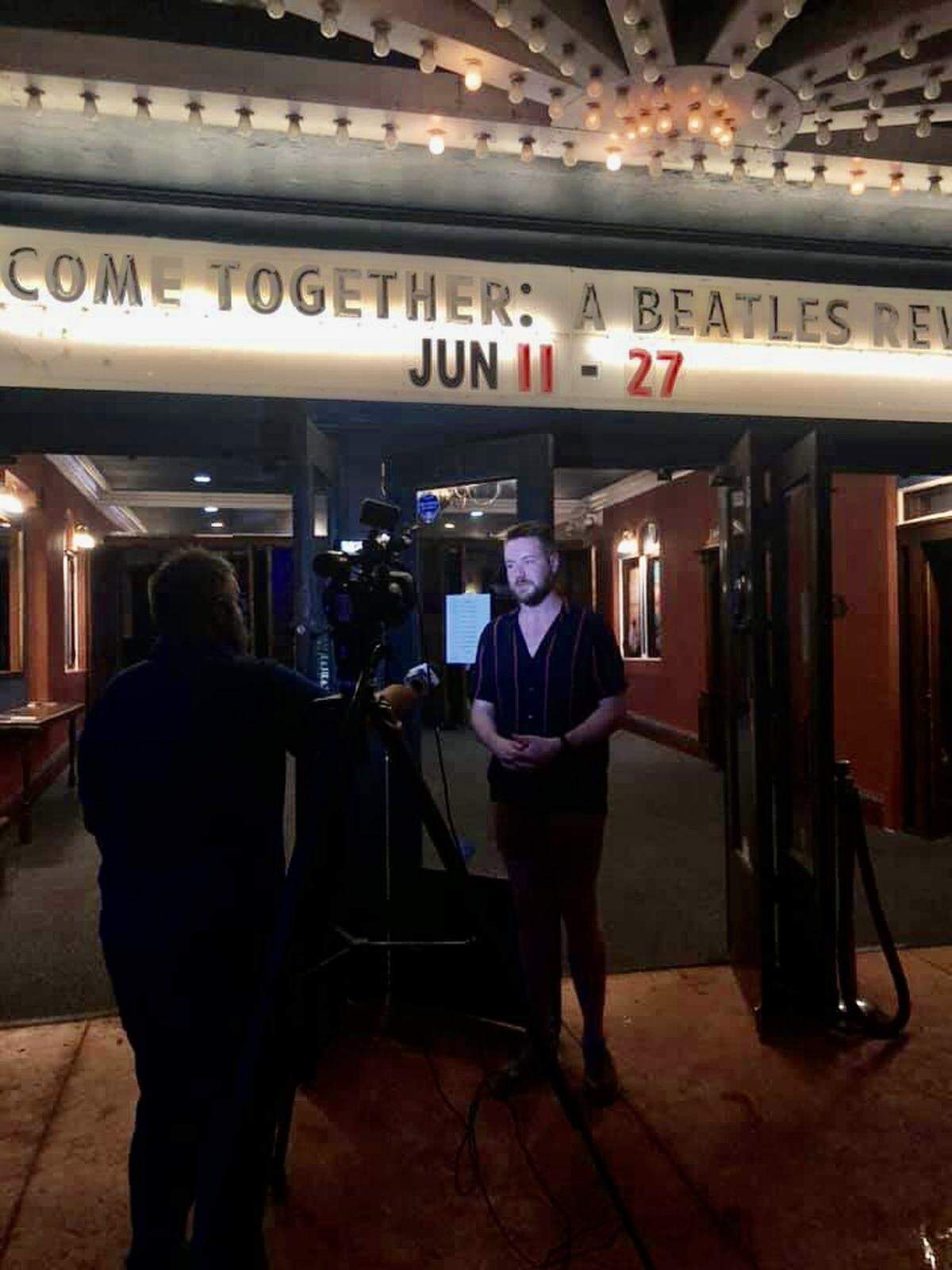 Crown Uptown Theatre’s general manager, Max Wilson, is interviewed by news crews after lightning struck the building in the middle of a performance, causing the audience to have to evacuate.
