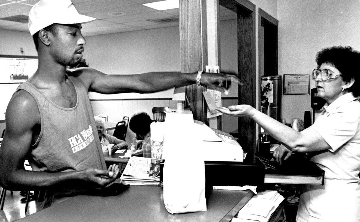 Mary Stratton is pictured in 1989 taking payment from a longtime customer at the second Bill’s Big 6 location, 424 E. Central, where El Patio now operates.