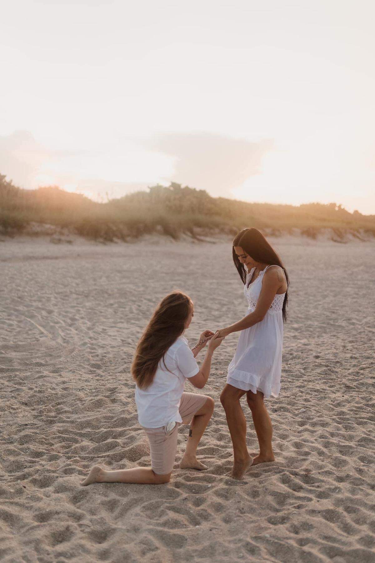 Jessica Robinson, left, proposing to Ali Waggy on a family trip to Florida in July. The two planned to marry at the Barn at Grace Hill even before their engagement but now are looking elsewhere since the venue does not approve of gay marriage.