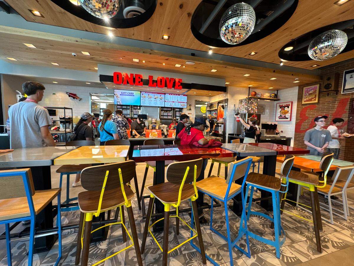 The new Raising Cane’s is decorated with colorful chairs and sparkling disco balls.