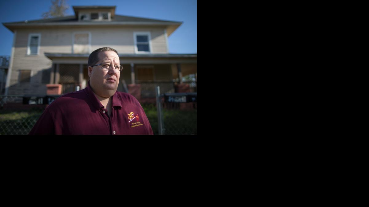 West High School principal Joel Hudson stands outside a boarded-up house across the street from the school. The United Way plans to invest $1 million in a year in an attempt to improve graduation and literacy rates among children in the area served by West.

