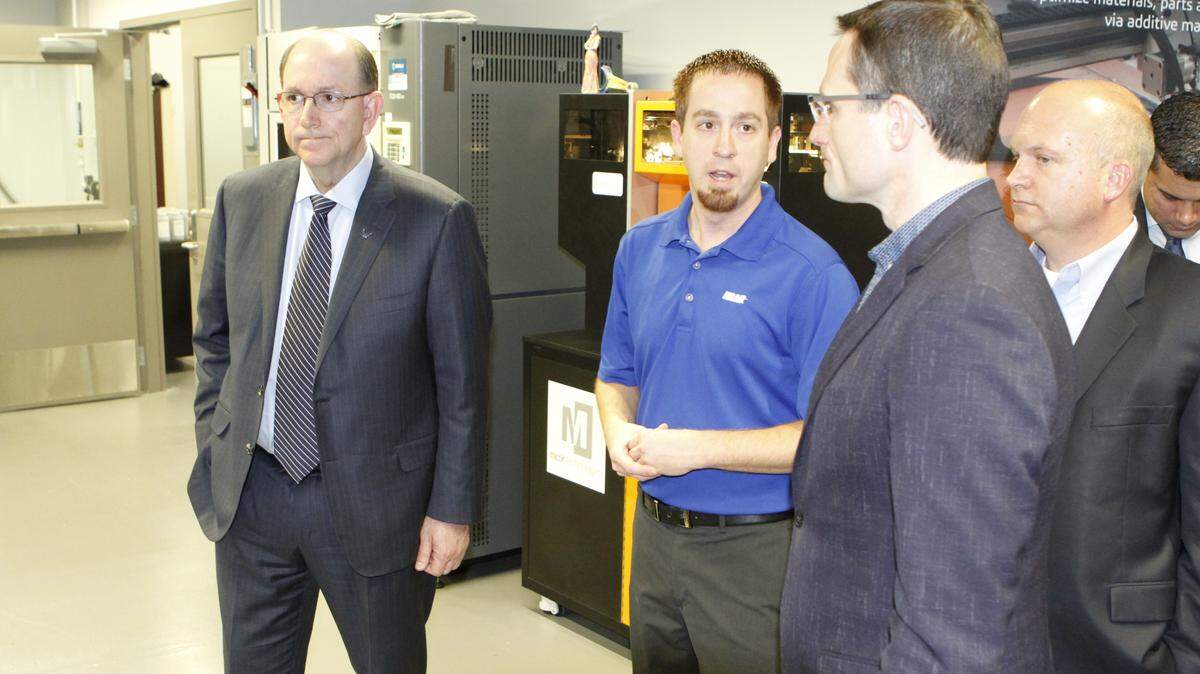 Air Force Under Secretary Matthew Donovan, left, listens to Chris Rempe, manager of the reverse engineering and additive manufacturing lab at Wichita State University, during a tour Friday. To Rempe’s right is John Tomblin, WSU’s vice president for research and technology transfer, and Will Roper, assistant secretary of the Air Force for acquisition, technology and logistics.