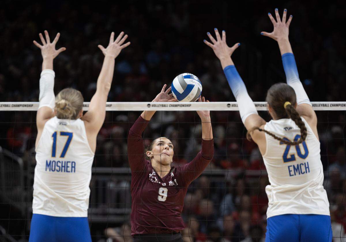 Texas A&M’s Logan Lednicky sets the ball between Pittsburg’s Brooke Mosher, left, and Abbey Emch, during their semifinal match at the NCAA Volleyball Championship on Thursday night at the T-Mobile Center.