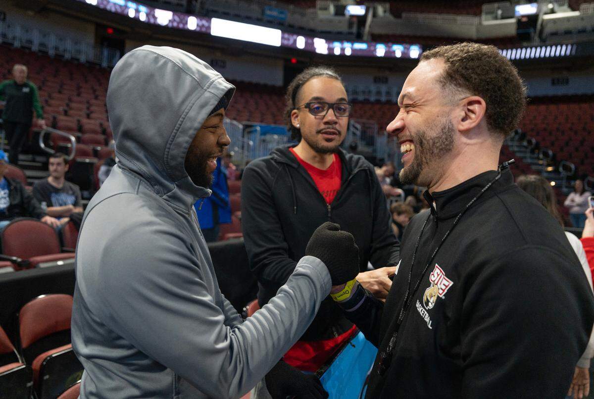 SIU Edwardsville assistant coach Jay Bradley, right, is greeted by Jalen Smith, left, and his brother Clayton Bradley, center, after an open practice at the 2025 NCAA Division I Men’s Basketball Championship at INTRUST Bank Arena. SIU Edwardsville faces Houston in the first round on Thursday. Bradley is a Wichita native chasing his coaching dream.