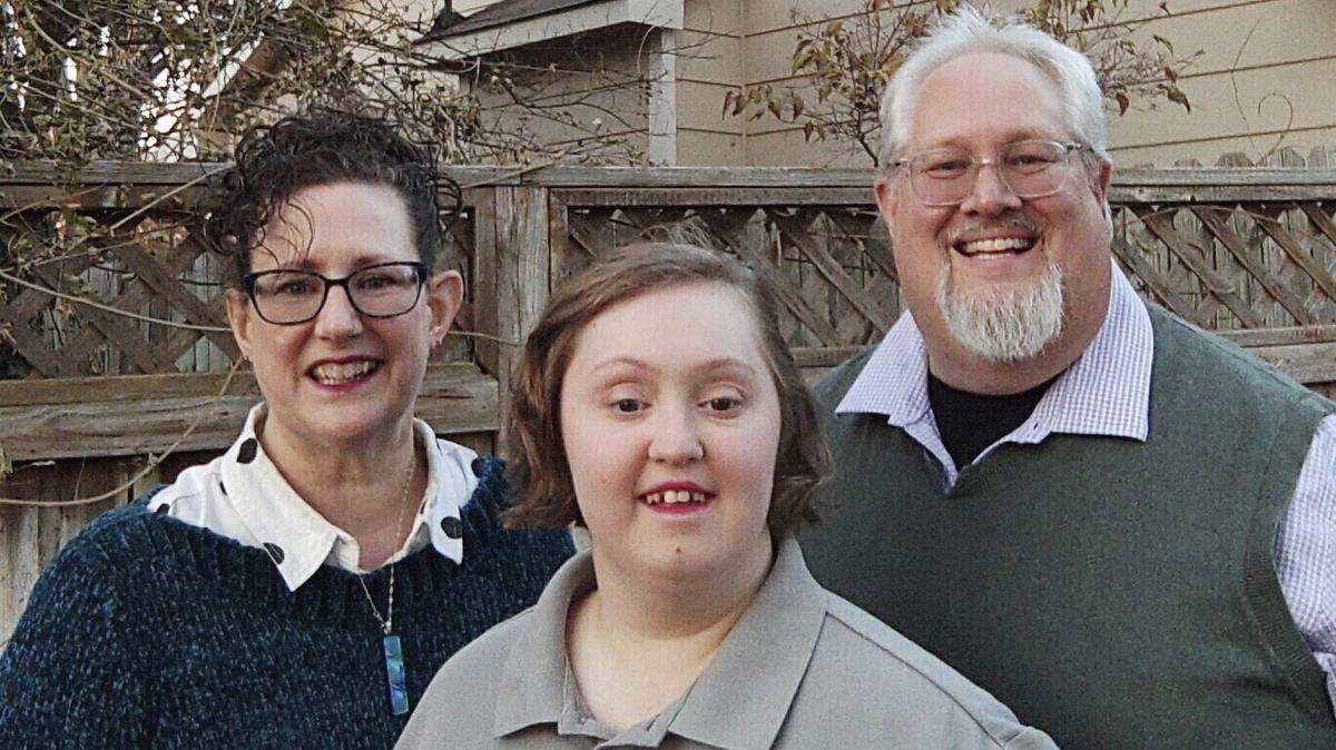 In this photo from November 2023 provided by Marvin J. Miller, Teresa Miller, left, Lilly Miller, center, and Marvin Miller pose on the back porch of their home in Wichita. Lilly Miller, now 21, has Down syndrome and has been on a state waiting list for a day program and other services for 10 years.