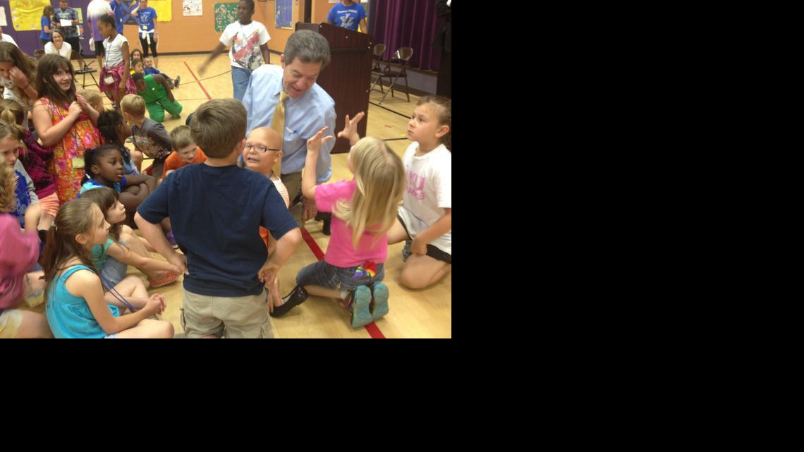 Gov. Sam Brownback talks to children at Henry Leavenworth Elementary School on Tuesday.

