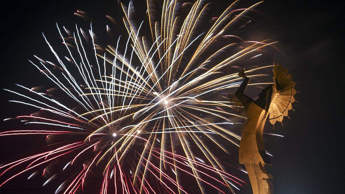A Fourth of July fireworks display explodes behind the Keeper of the Plains statue in downtown Wichita.