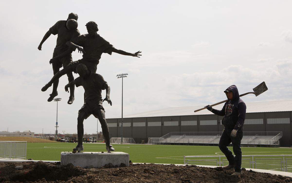 Workers move dirt around a large planter at the Stryker Sports Complex. Wichita officials have added $300,000 to the price tag of a new indoor soccer facility at the Stryker Sports Complex, to replace soil that heavy rain turned into a muddy mess. (April 3, 2019)