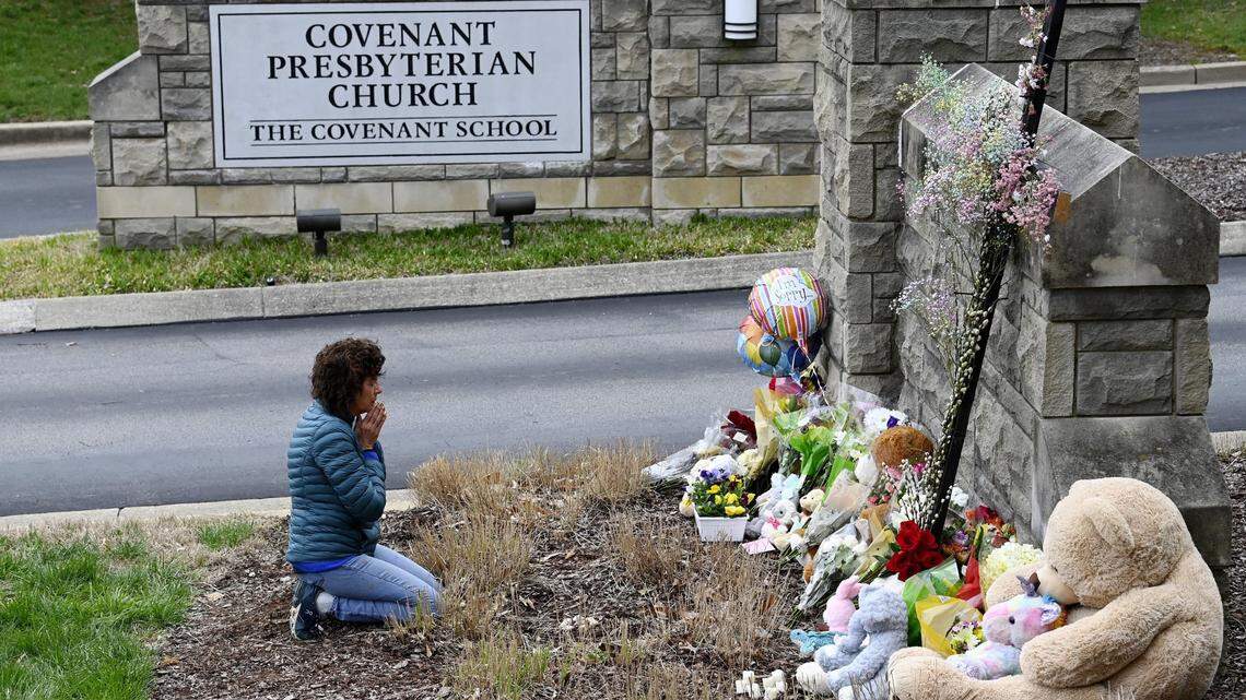 Robin Wolfeden prays in front of a makeshift memorial at the entrance to the Covenant School on Tuesday, March 28, 2023, in Nashville, Tenn. Three children and three school staff members were killed by a former student in Monday’s mass shooting.