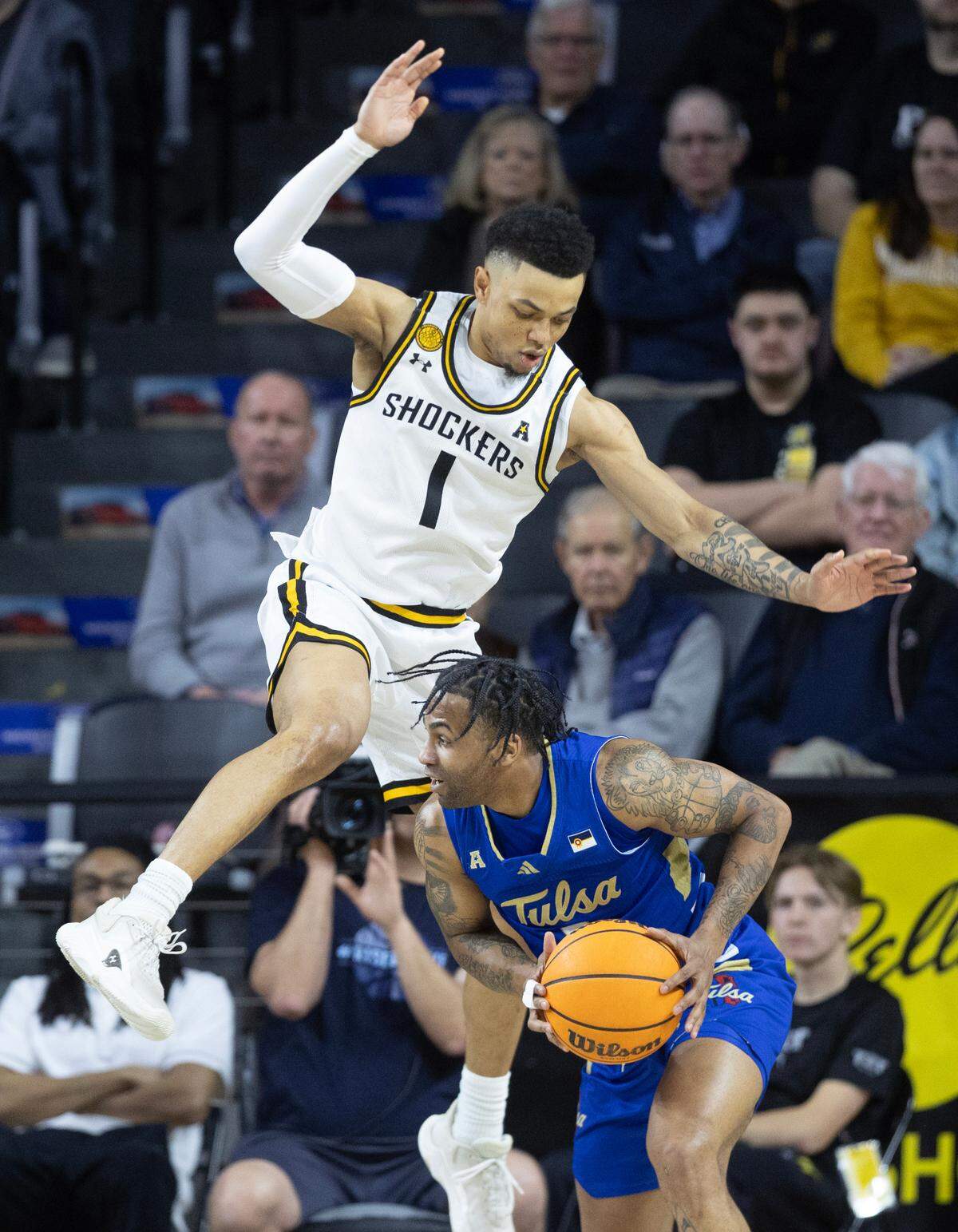 Wichita State’s Xavier Bell jumps over Tulsa’s Dwon Odom during the first half of their game Sunday at Koch Arena. 