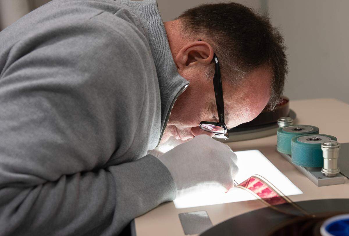Shawn Rhodes, director of digital services for the U.S. division of R3Store Studios, examines a film before digitizing it.