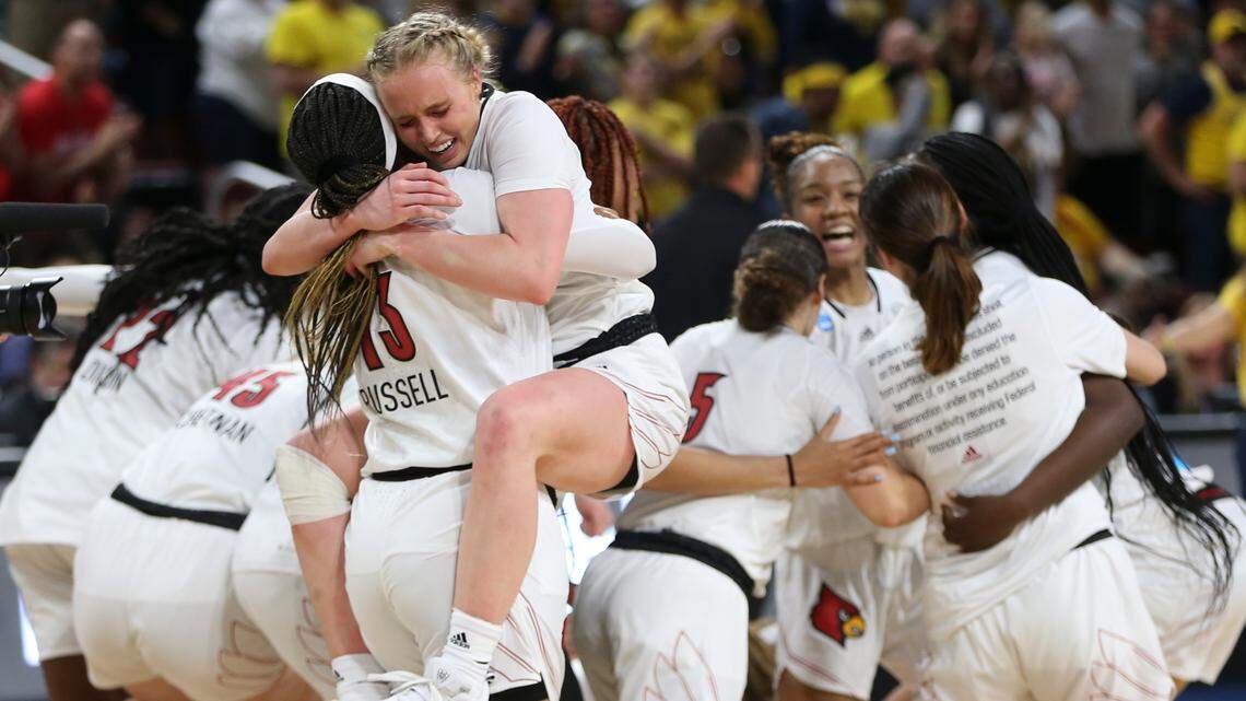 Louisville’s Hailey Van Lith jumps into the arms to teammate Merissah Russell after the Cardinals clinched a spot in the Final Four with a win over Michigan. Van Lith had 22 points in the win.