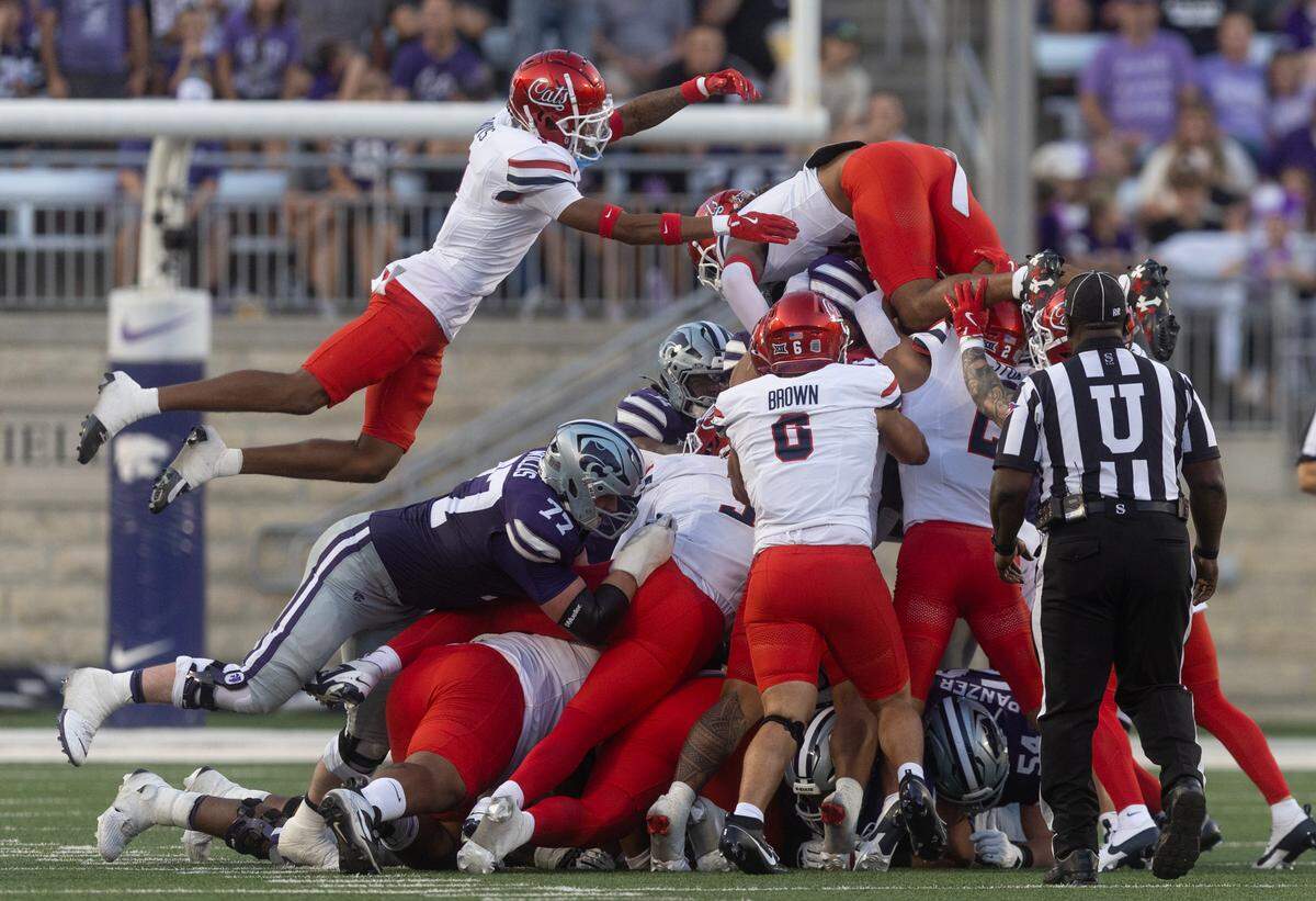 Arizona defenders try and stop Kansas State quarterback Avery Johnson on 4th down during the first quarter of their game on Friday night at Bill Snyder Family Stadium.