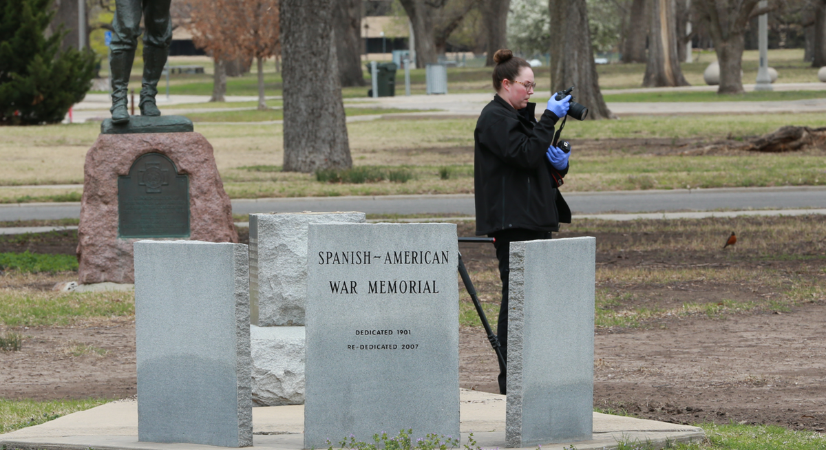 A crime scene investigator takes a photo and collects evidence after a cannon was stolen from the Spanish-American War monument in Central Riverside Park. The cannon was later recovered in pieces.