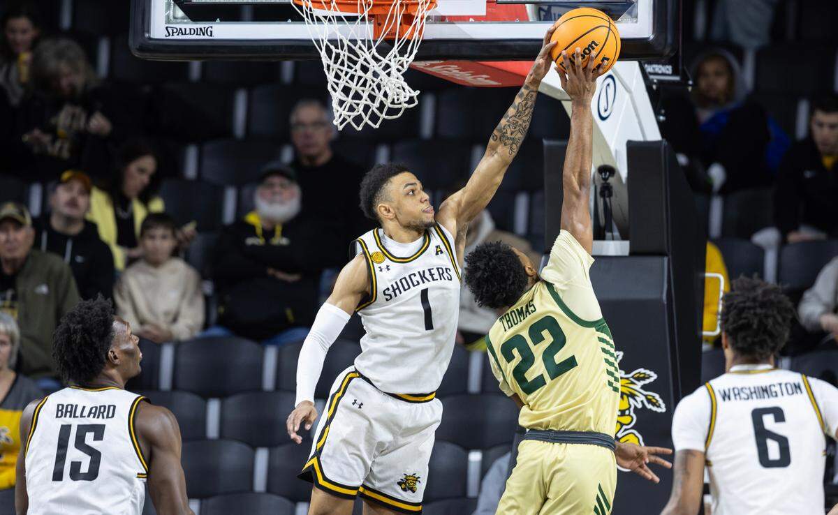 Wichita State’s Xavier Bell blocks the shot of Charlotte’s Jaehshon Thomas during the first half of their game on Tuesday night at Koch Arena.