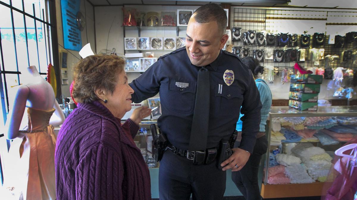 Wichita police officer Paul Cruz, right, visits with Moda Jalisco clothing store owner Rosario Oropeza near Broadway and 21st St. on Friday. He is also on the Wichita Police Department's Hispanic Advisory Board.