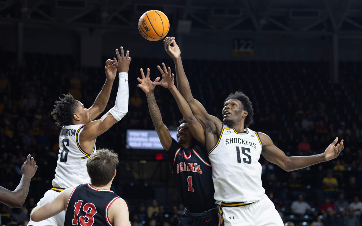 Wichita State’s Corey Washington, left, and Quincy Ballard, right, battle Friends University’s Cahlese Lee for a rebound during the first half on Sunday at Koch Arena. 