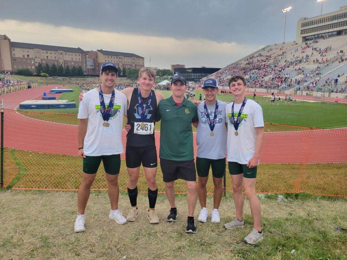 Justus Reynolds, a junior at Eisenhower, is joined by his father, Tim, the hurdles coach at Bishop Carroll, and his three hurdlers. All four athletes placed in the Class 5A 300-meter hurdles with Justus winning the title.