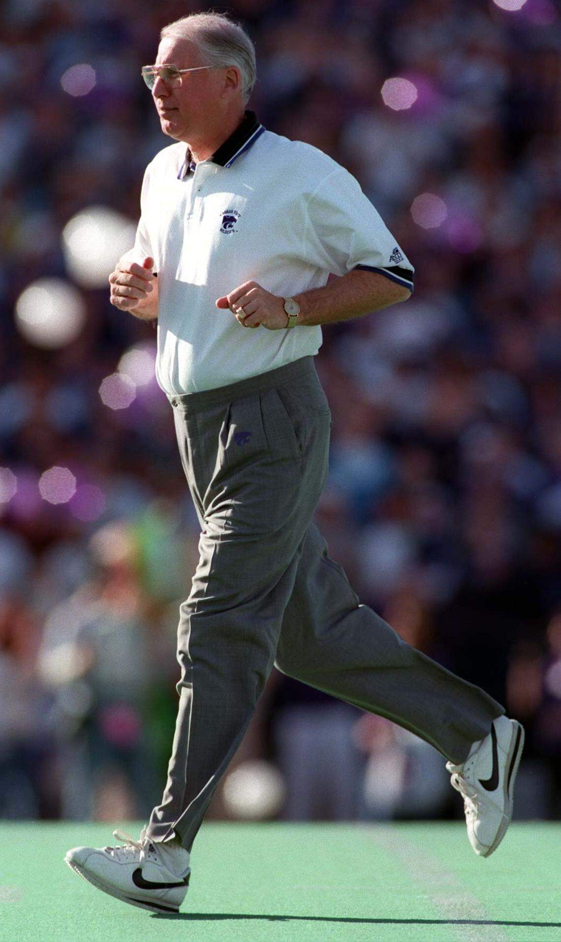 Photo by John Sleezer/Staff. Kansas State University head football coach Bill Snyder runs onto the field during introductions prior to the start of a November 18, 1995 game against Colorado in Manahattan, Kansas. photo by john sleezer/staff.