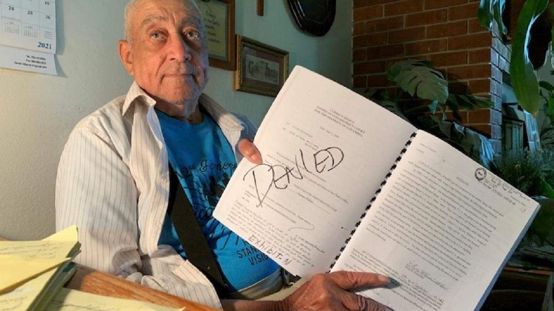 Bernard Bates holds a notebook of documents from the lawsuits he’s been a part of while trying to get his farmland back.