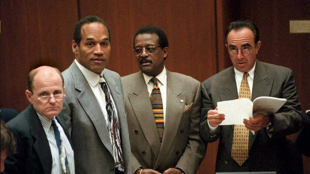 (FILE PHOTO) Murder defendant O.J. Simpson (second left) stands with his attorneys Robert Blasier (left), Johnnie Cochran Jr. (second from right) and Robert Shapiro (right) as the jury enters the courtroom April 26, 1995, in the O.J. Simpson murder trial. (Vince Bucci/Pool/AFP via Getty Images/TNS)