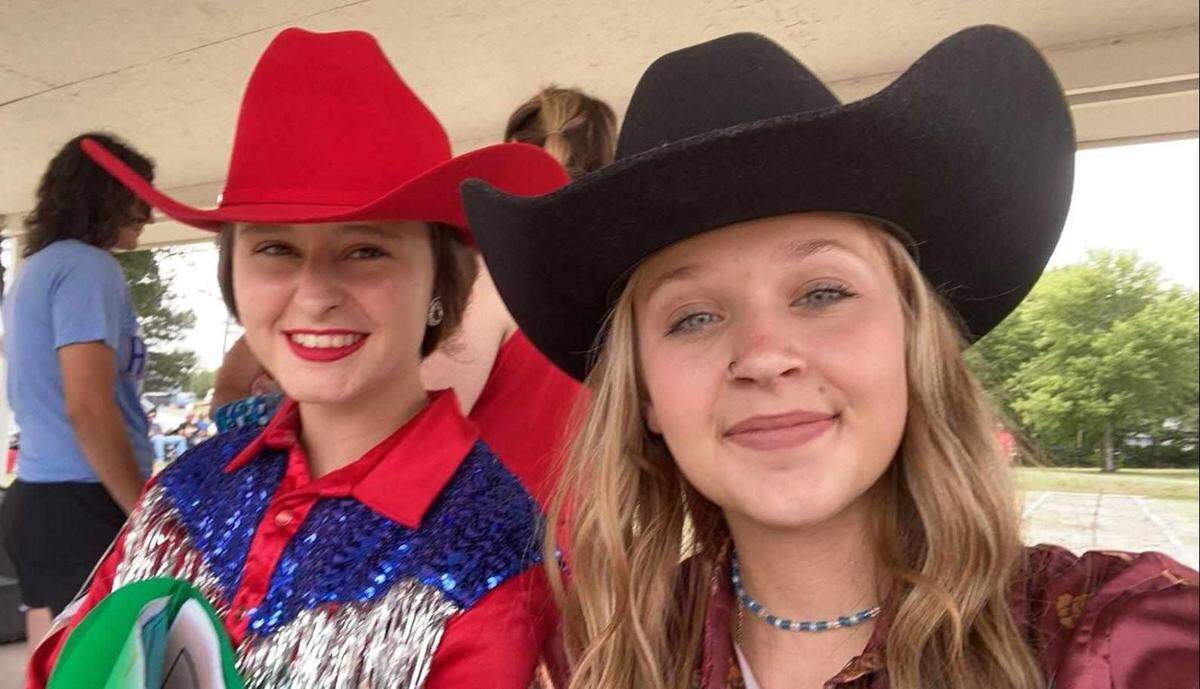 Emma Brungardt, left, and Laney Thomas take a photo together while they were selling rodeo tickets in June 2022 in Jamestown, Kansas.