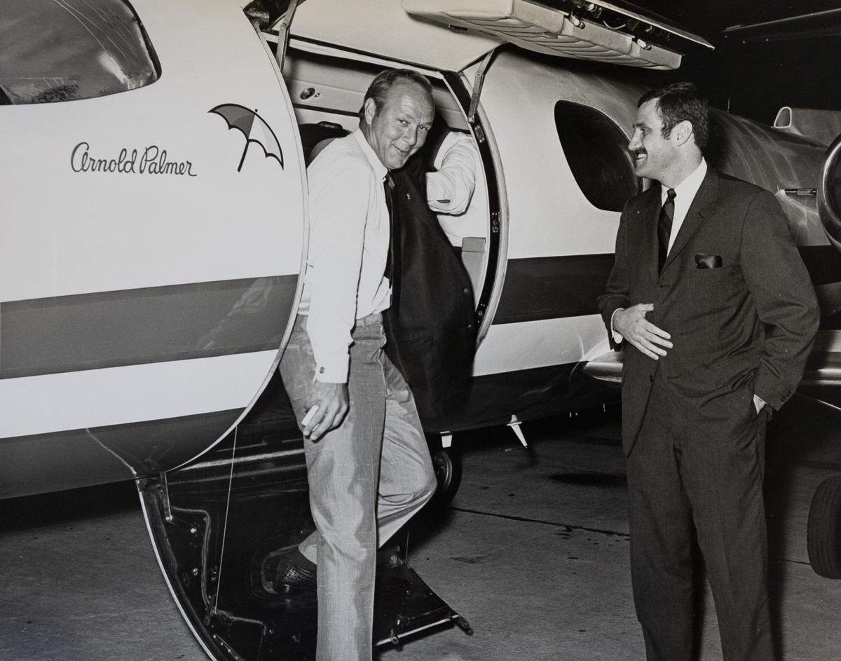 Al Higdon, right, with golfer Arnold Palmer by Palmer’s Learjet.