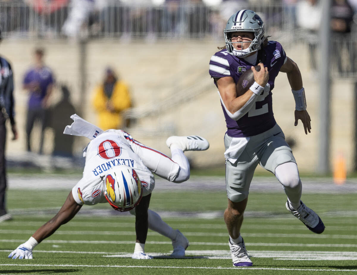 Kansas State quarterback Avery Johnson jukes Kansas defender Austin Alexander during the fourth quarter of their game in Manhattan on Saturday.