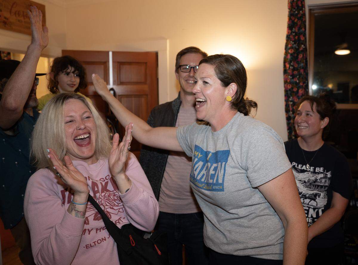 Amy Warren, right, high-fives supporters during an election night party at her home. Warren won the election for Wichita school board District 6 beating incumbent Hazel Stabler.