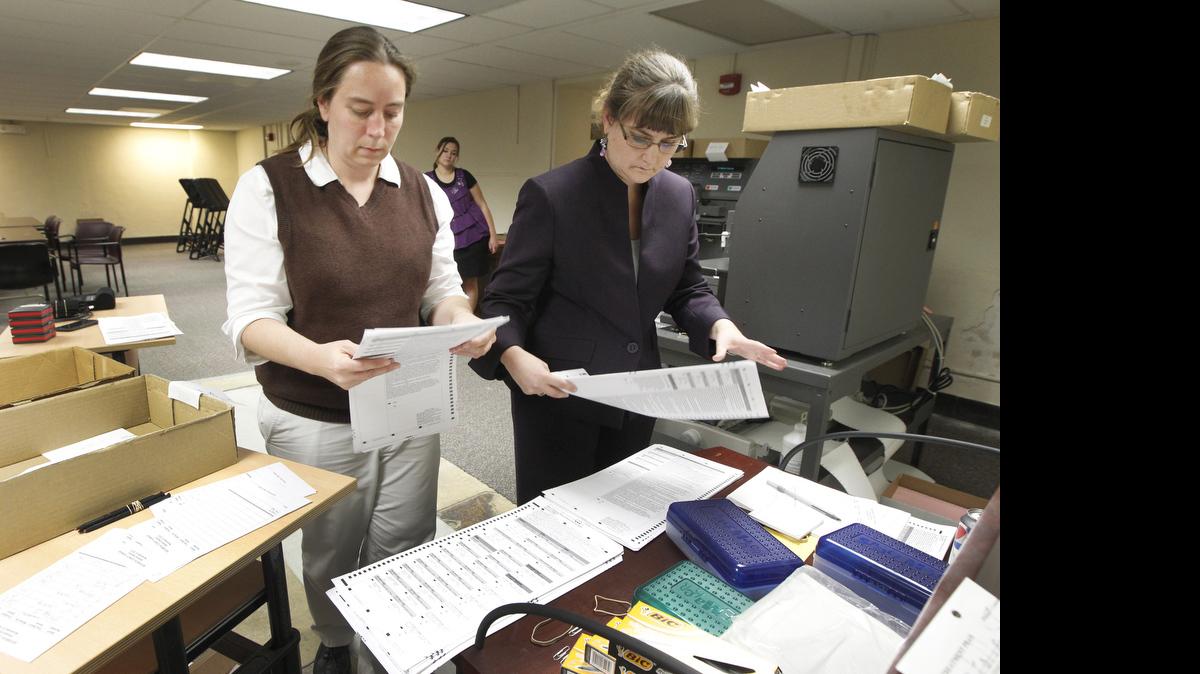 Elections official Dawn harris, left, and Elections Commissioner Tabitha Lehman, right, count some ballots late Tuesday night at the Elections Commissioner's office. (Nov. 6, 2012)