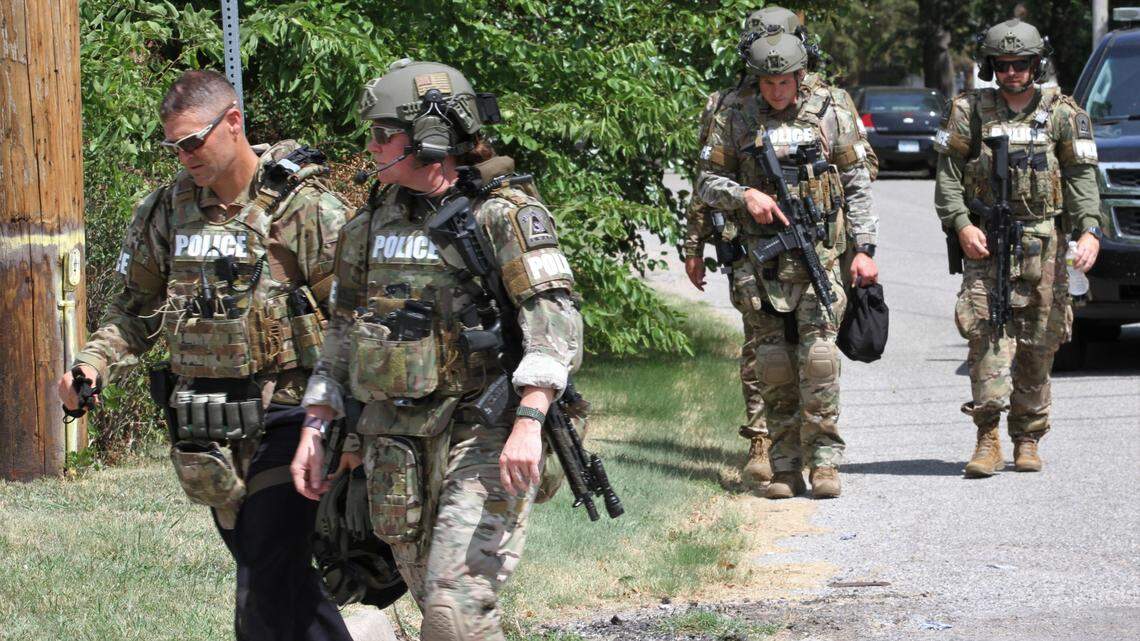 SWAT team officers retreat from a home in north Wichita where Travis Davis barricaded himself on Aug. 7, 2022.