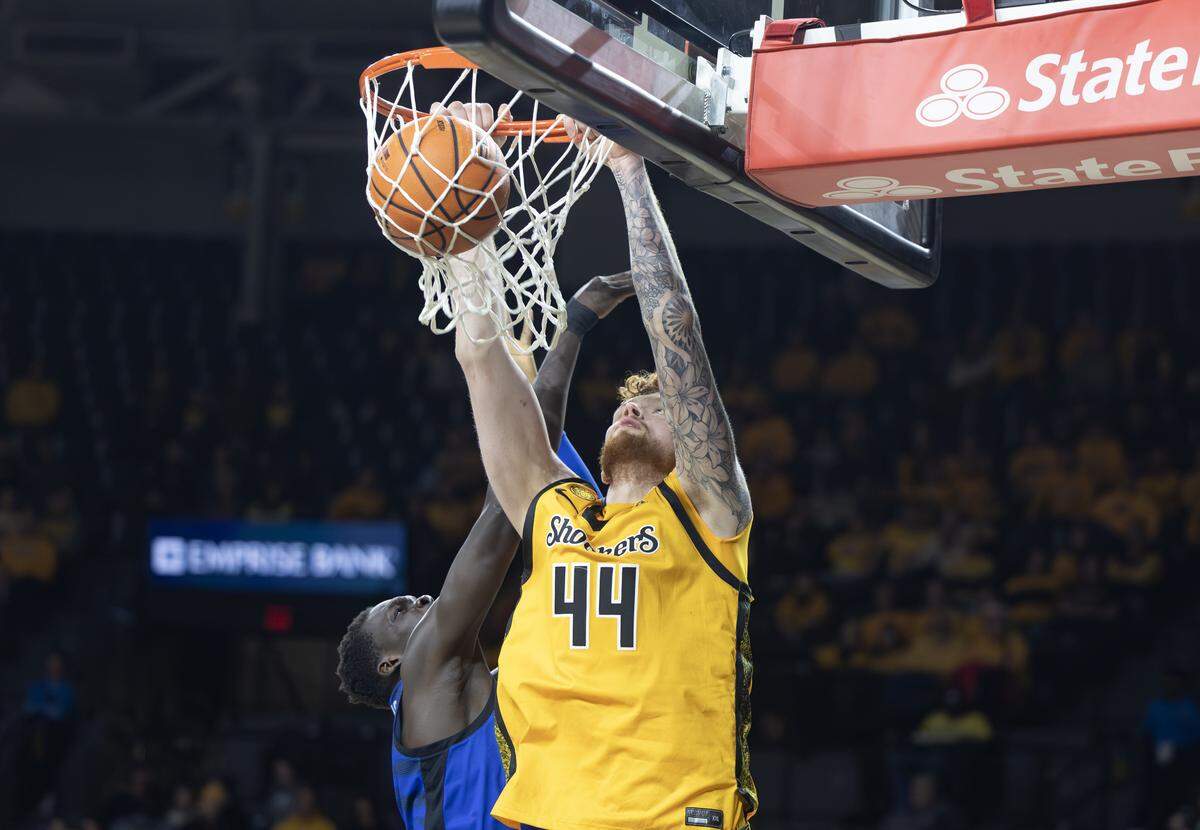 Wichita State’s Will Berg dunks the ball over Memphis’ Simon Majok during the second half at Koch Arena on Saturday.
