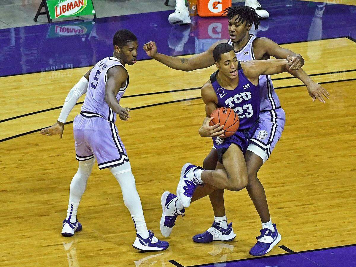 TCU forward Jaedon Ledee drives the ball against Kansas State players Rudi Williams (left) and Carlton Linguard (right).