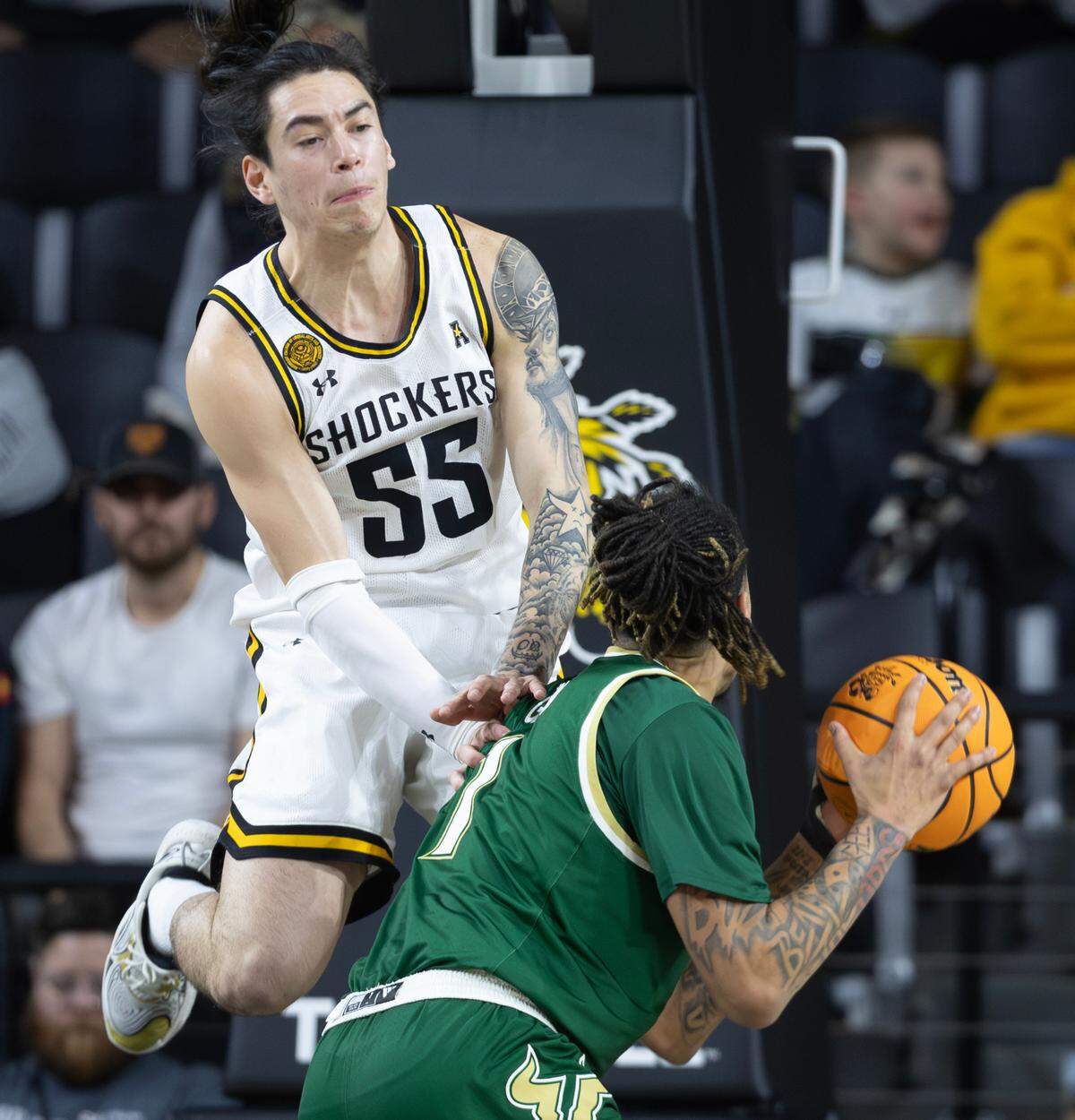Wichita State’s Bijan Cortes fouls South Florida’s De’Ante Green during the first half of their game on Monday night at Koch Arena.