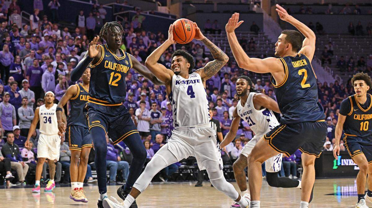 P.J. Haggerty #4 of the Kansas State Wildcats drives to the basket between defenders Dhiaukuei Manyiel Dut #12 and John Camden #2 of the California Golden Bears, in the second half at Bramlage Coliseum on November 13, 2025 in Manhattan, Kansas.