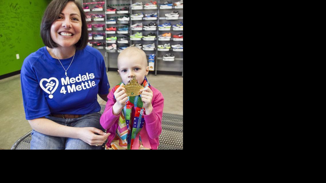 Veronica Kellogg with medal winner Sophia Stepien, 4. Kellogg has helped start the Kansas chapter of the Medals4Mettle, whose mission is to recognize individuals who are dealing with chronic or debilitating illnesses. 


