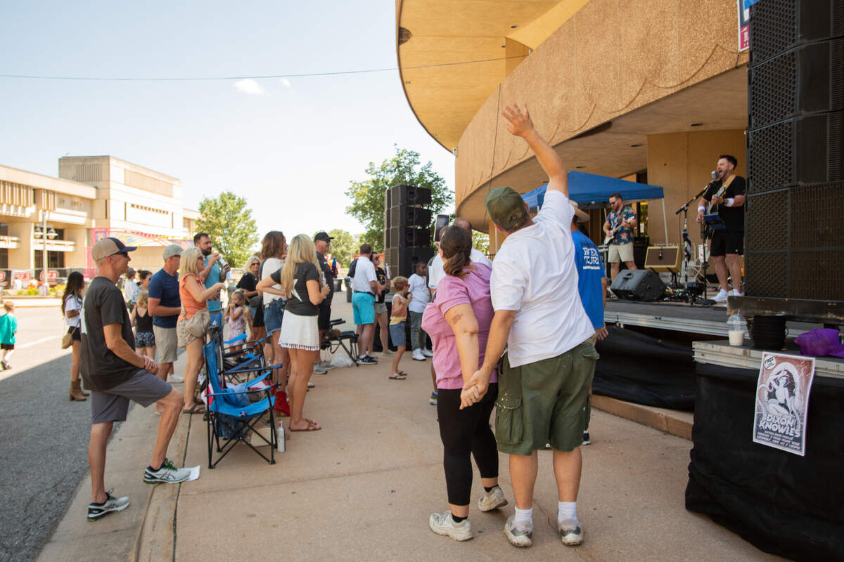 Riverfest attendees dance to Dixon Knowles, a local cover-band in Wichita, during the second day of the nine-day festival. Dixon Knowles played a variety of rock hits, such as “Last Night” by The Strokes.