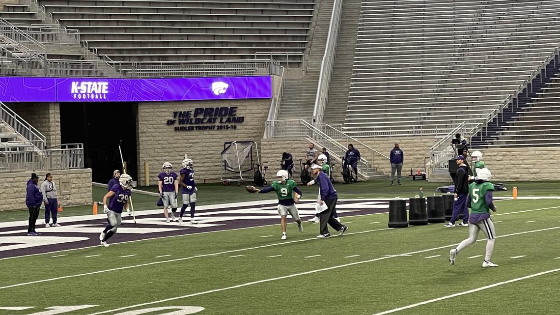 Kansas State quarterback Adrian Martinez tosses an option pitch to Jordan Schippers at a spring football practice at Bill Snyder Family Stadium in Manhattan.