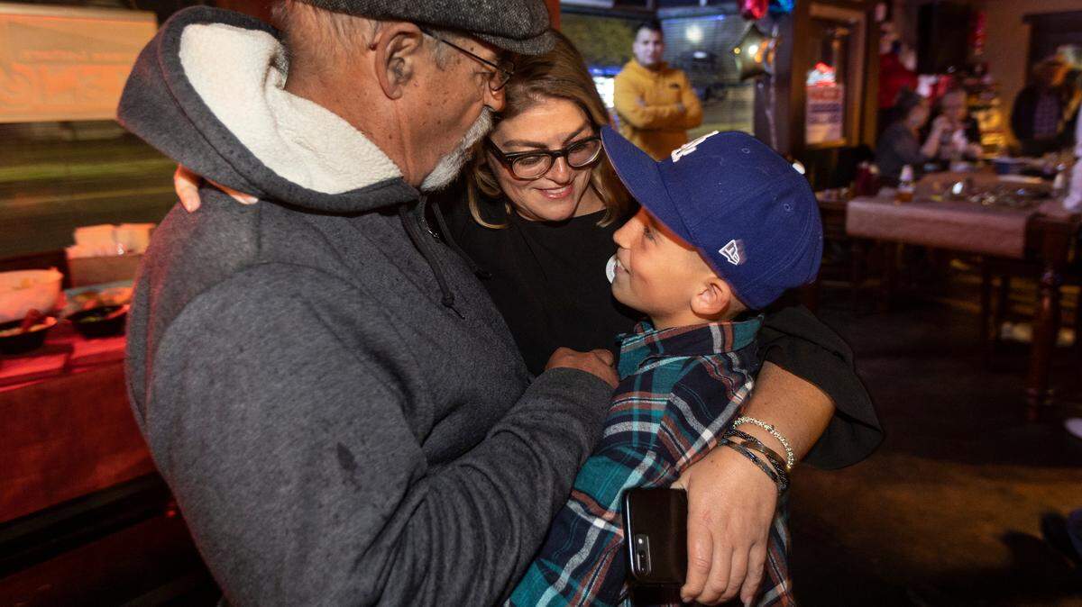 Wichita City Council candidate Maggie Ballard, middle, hugs her son Paxton Burns, right, and her father, Doug Ballard, during her election party at Merle’s on Tuesday night. Ballard led incumbent Cindy Claycomb in unofficial results in District 6.