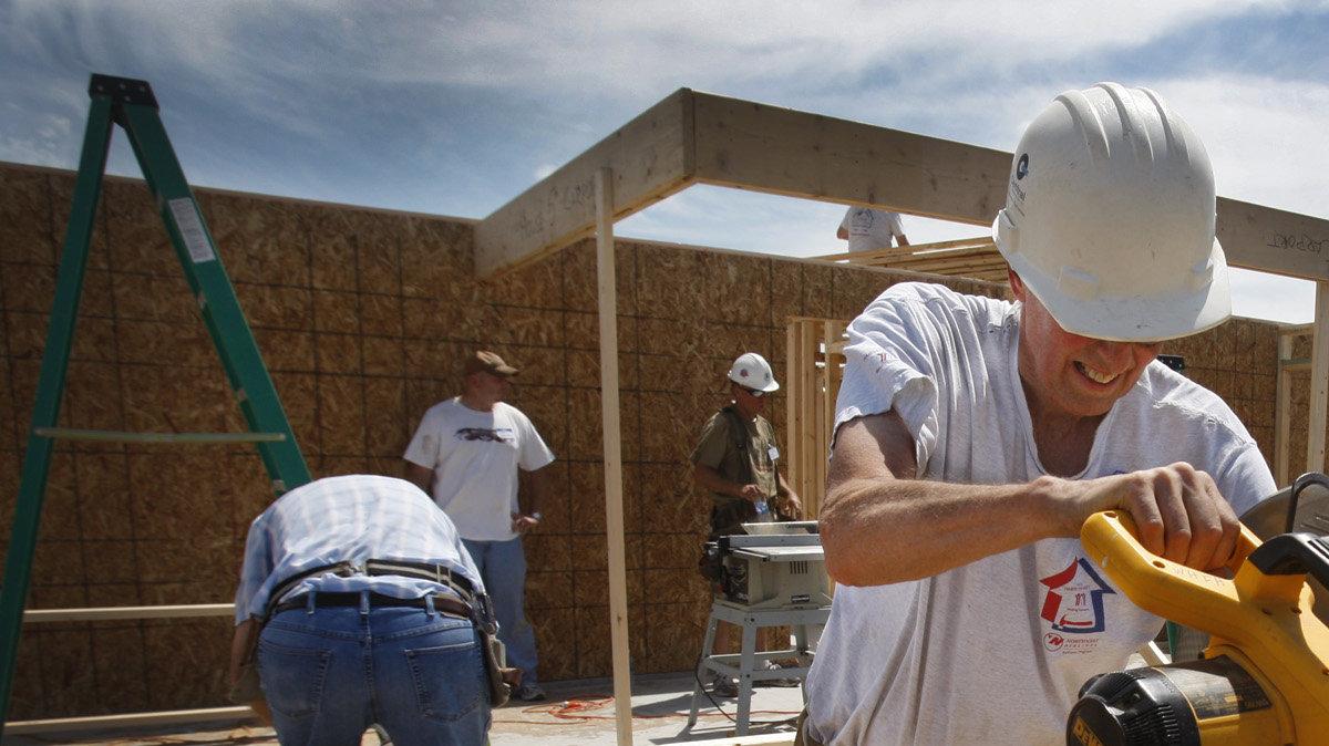 Volunteer Pat Eckelberry saws a piece of wood as he and other volunteers for Wichita Habitat for Humanity work on seven houses at the Habitat South Village in 2010. (June 17, 2010)