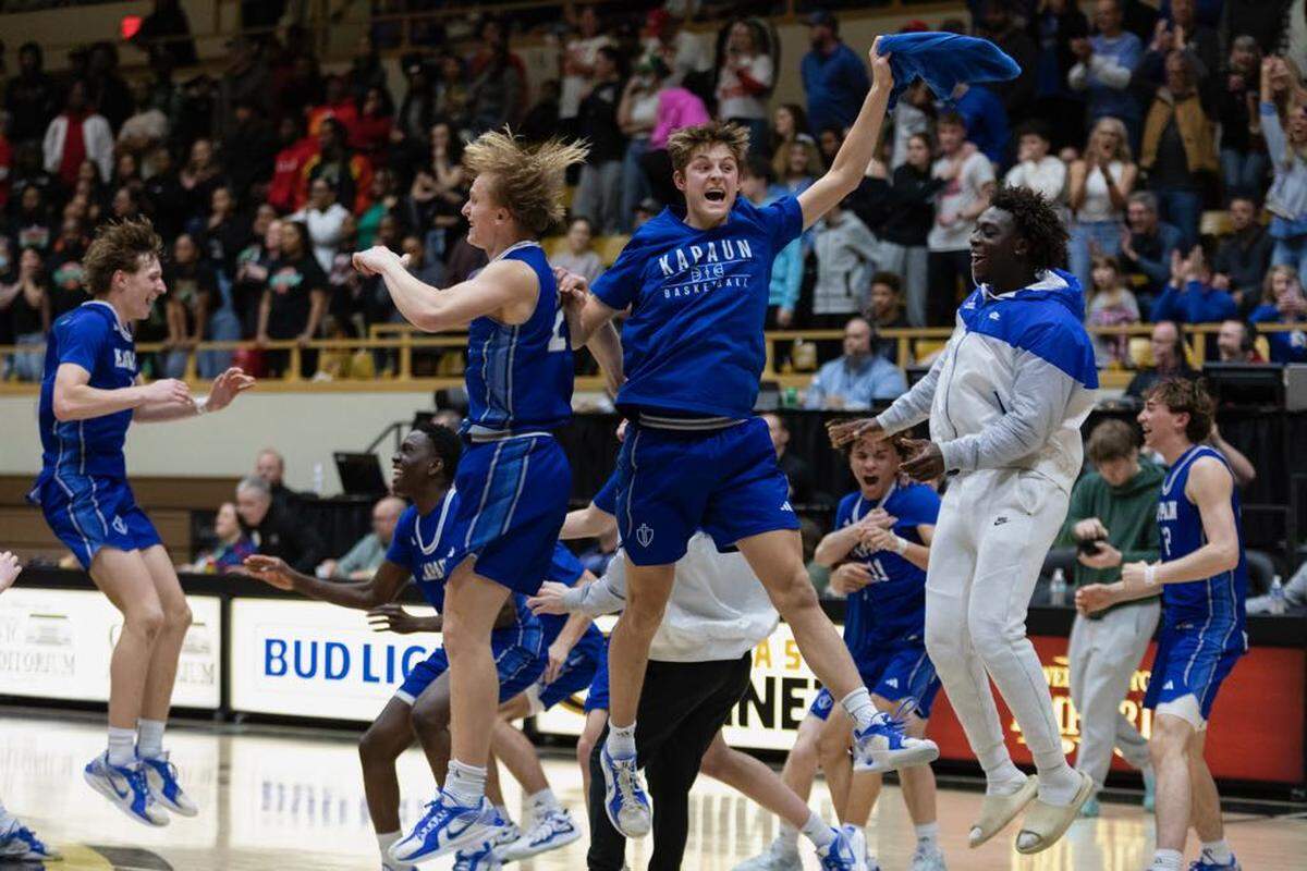 The Kapaun Mt. Carmel boys basketball team celebrates winning its second straight Class 5A championship with an overtime win over Highland Park on Saturday in Emporia.