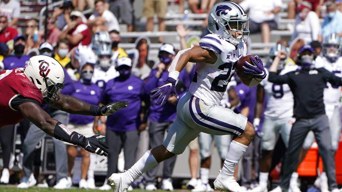 Kansas State running back Deuce Vaughn (22) avoids a tackle by Oklahoma defensive lineman Perrion Winfrey, left, as he carries for a touchdown in the second half of an NCAA college football game Saturday, Sept. 26, 2020, in Norman, Okla. (AP Photo/Sue Ogrocki).