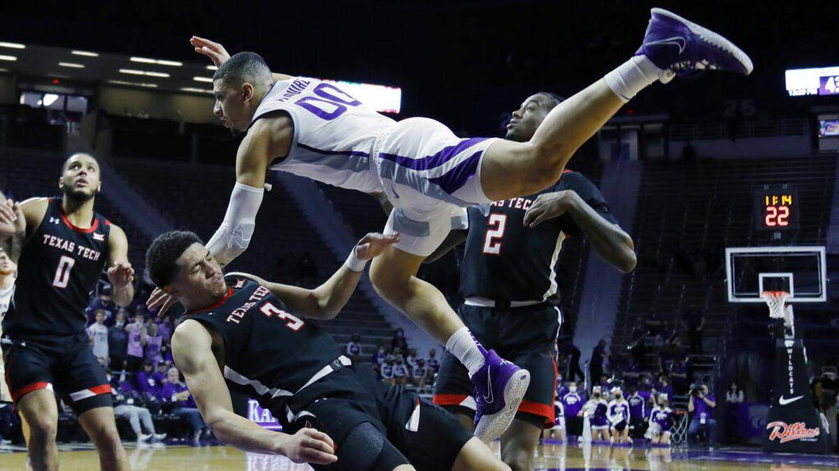 Kansas State guard Mike McGuirl (00) collides with Texas Tech guard Clarence Nadolny (3) while attempting to score during the second half of an NCAA college basketball game on Saturday, Jan. 15, 2022 in Manhattan, Kan. McGuirl was called for charging. Kansas State beat No. 19. Texas Tech 62-51. (AP Photo/Colin E. Braley)