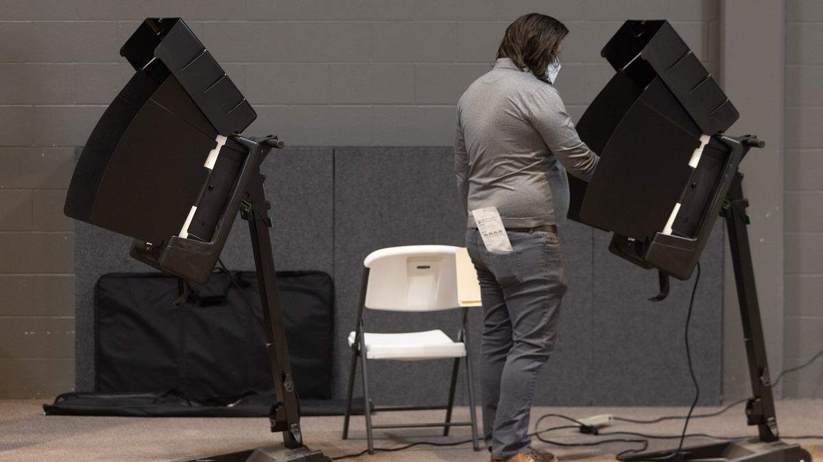 A voter casts their ballot at New Life Covenant Church on Tuesday morning.