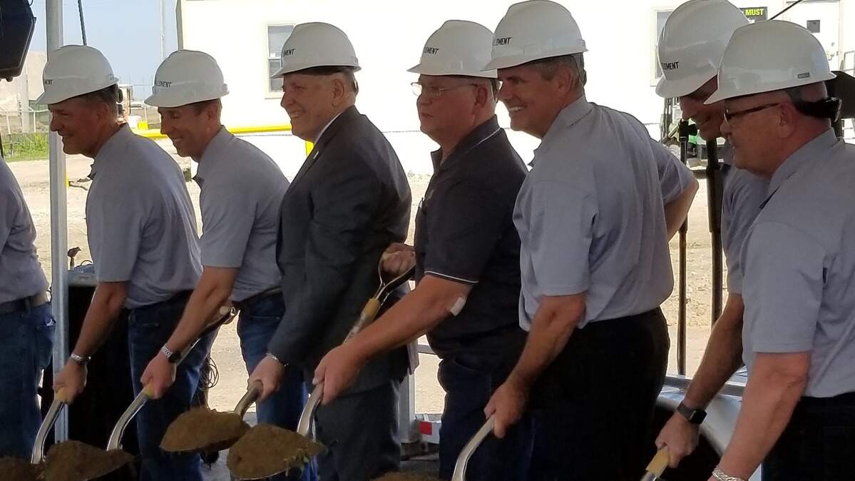 Local officials, including Sedgwick County Commissioner Dale Dennis in the gray suit and Colwich Mayor Terry Spexarth in the gray polo shirt, turn a shovel full of dirt in a ceremony marking the start of construction for a $175 million ethanol plant in Colwich on Monday.