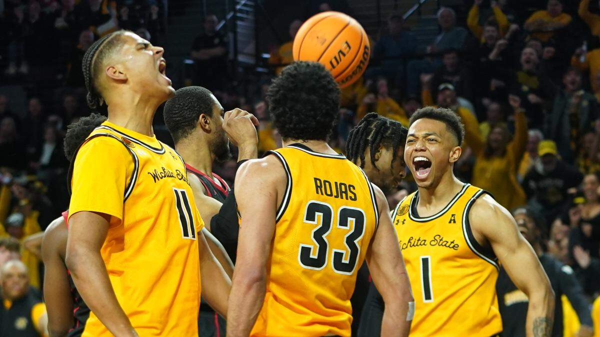 Wichita State University’s Kenny Pohto, left, and James Rojas, center, and Xavier Bell, right, cheer after Rojas was fouled and made a basket against the University of Houston during their game at Koch Arena.