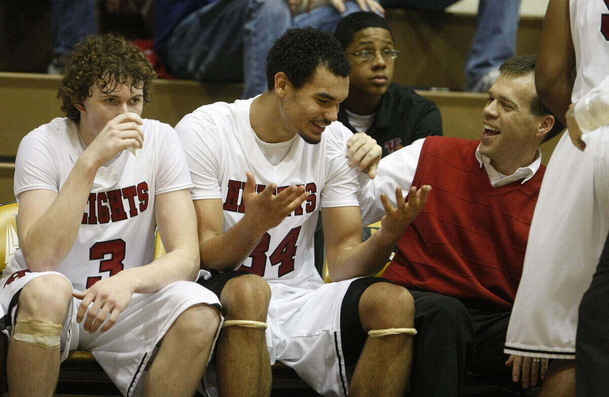 Heights' Perry Ellis has a laugh with assistant coach Gary Thomason after coming out in the final minute and half of their quarterfinal game with Manhattan at the Class 6A state tournament in Emporia on Thursday. (March 11, 2010)