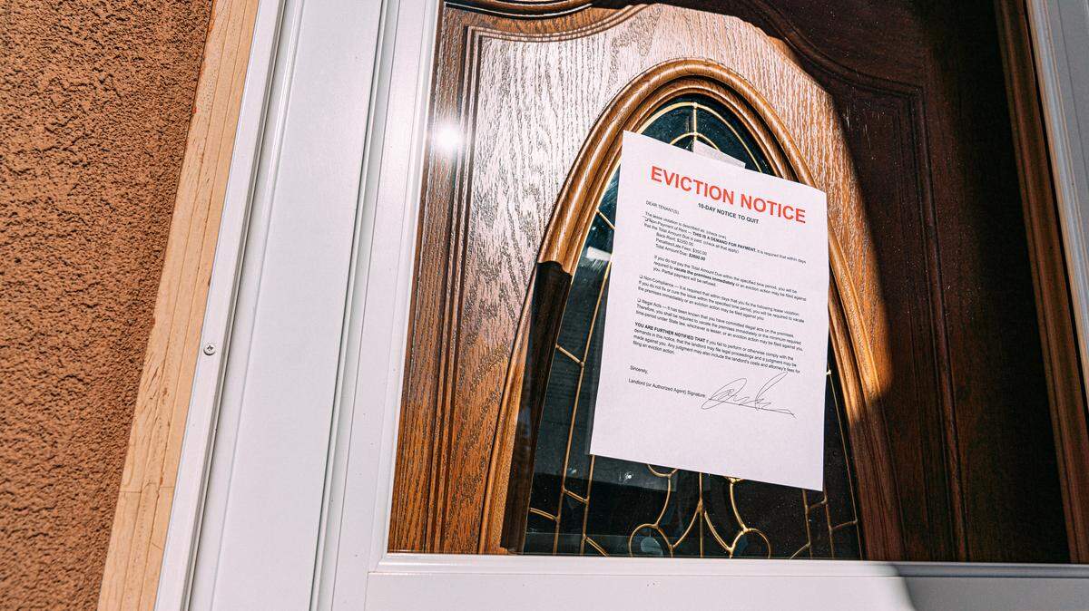 10-Day Notice to Quit Paper sign at the Glass Front Door of a Home in a Residential Suburban Neighborhood