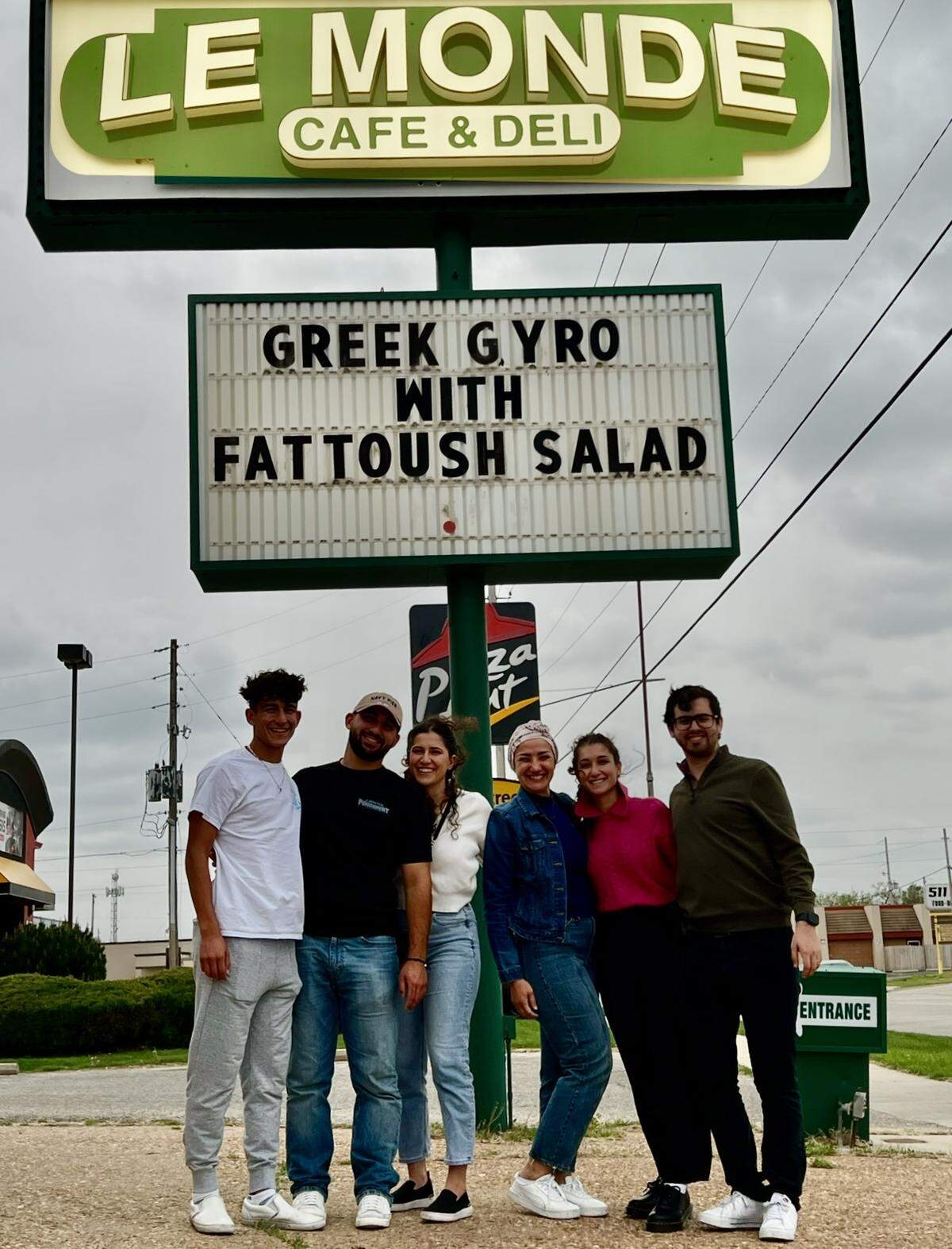 Lilas Krichati, third from right, is pictured with her children in front of Le Monde Cafe & Deli.