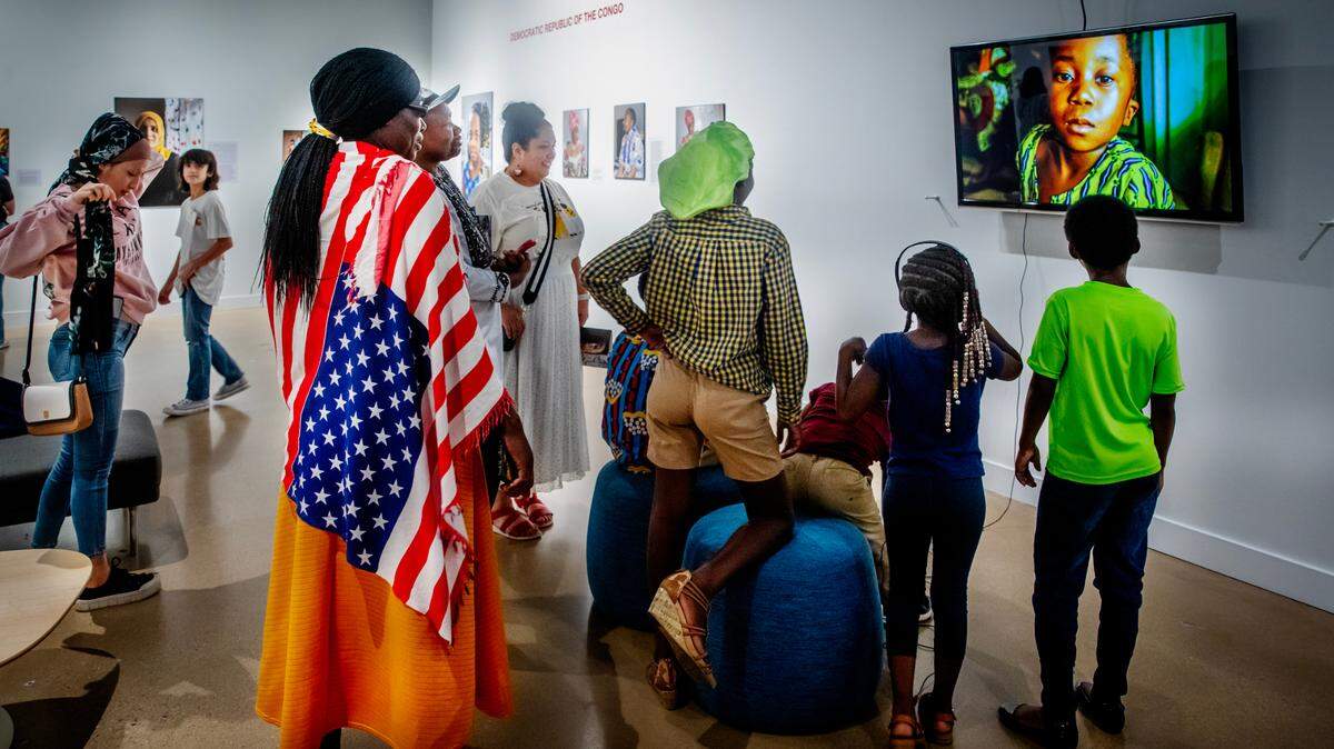 A refugee family from the Democratic Republic of Congo watch a video created for the “Where We Belong: Refugee Stories from Wichita” exhibition at the Ulrich Museum of Art on the Wichita State campus. The family is one of five refugee families whose stories of being displaced because of war, violence or persecution are told through the exhibition.